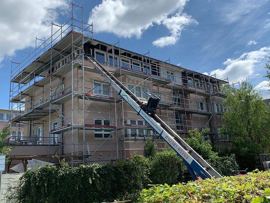 Gebäude mit Gerüst und firmiertem Kran